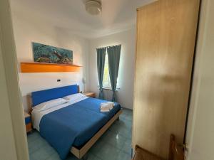 una camera con un letto blu e una finestra di La Nassa a San Domino