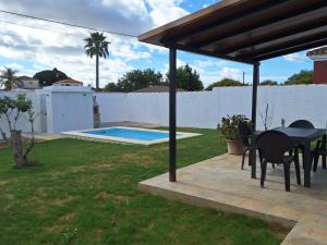 um pátio com uma mesa e cadeiras e uma piscina em Casa Boyal em Hozanejos