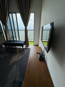 a room with a bed and a balcony with windows at Skylake Residence Luxury Family Vacation in Puchong