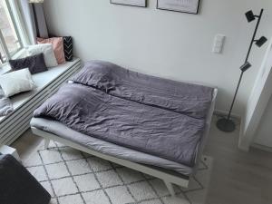 a bed with a gray comforter in a bedroom at Valjastehdas in Oulu