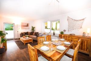 a dining room and living room with a table and chairs at Ferienhaus Auszeit - Wohnung "Strandmuschel" in Grömitz