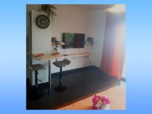 Cette chambre comprend un bureau avec un ordinateur et une horloge. dans l'établissement NEW Joli Studio avec Vue mer imprenable - wifi, à Saint-Leu