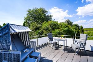 グレーミッツにあるFerienhaus Auszeit - Wohnung "Salzbrise"の- 野原の景色を望むデッキ(椅子、テーブル付)