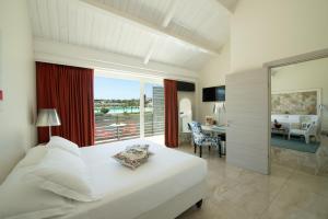 シラクーサにあるWellness Spa Hotel Principe Fitaliaのベッドルーム(大きな白いベッド1台付)、ダイニングルームが備わります。