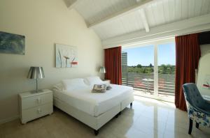 シラクーサにあるWellness Spa Hotel Principe Fitaliaのベッドルーム(白いベッド1台、大きな窓付)