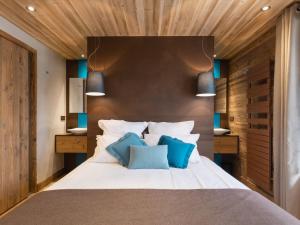 a bedroom with a large white bed with blue pillows at Appartement La Clusaz, 4 pièces, 8 personnes - FR-1-304-176 in La Clusaz