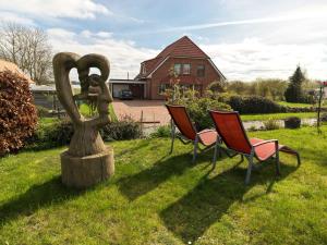 two chairs and a statue in the grass at Me-See in Malchow