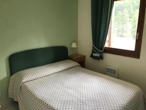- une chambre avec un lit doté d'une tête de lit verte et d'une fenêtre dans l'établissement Appartement Montgenèvre, 2 pièces, 6 personnes - FR-1-445-140, à Montgenèvre