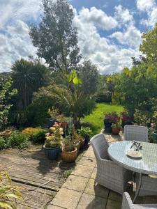 a patio with a table and chairs and potted plants at Gwynarth Guest House in Wadebridge