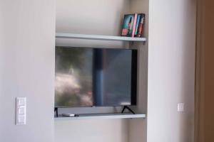 a tv on a wall with a window at Villa Ponti in Póndi