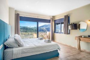 a bedroom with a bed and a large window at Villa Ponti in Póndi +47 photos