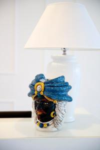 una lámpara sentada en una mesa junto a un jarrón en Tenuta Tropeano en Tropea