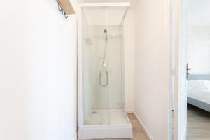 a shower with a glass door in a bathroom at S&K Suite Grande rue Roubaix - Chambre spacieuse et SDB privée - Netflix et Cuisine in Roubaix