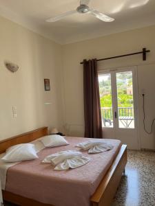 a bedroom with a bed with white sheets and a window at Alinda Hotel in Alinda