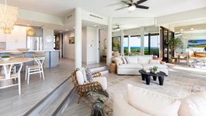 sala de estar con muebles blancos y cocina en THE POINT Contemporary 2BR Mauna Lani Point Home with Ocean View, en Waikoloa