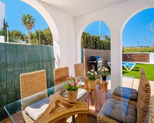 a patio with wicker chairs and a glass table at Salonica Beach Duplex III Javea Arenal by Rock Rentals in Jávea