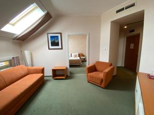 Boutique Hotel Sopianae في بيتْش: غرفة معيشة مع أريكة وكراسي في غرفة