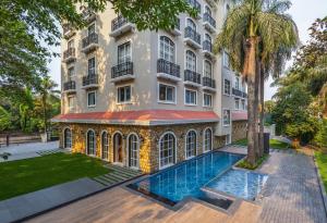 an exterior view of a building with a swimming pool at Enrise by Sayaji Lonavala in Lonavala