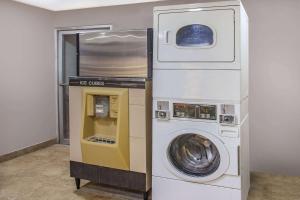 a washing machine and a washer and dryer in a room at Super 8 by Wyndham Redlands/San Bernardino in Redlands