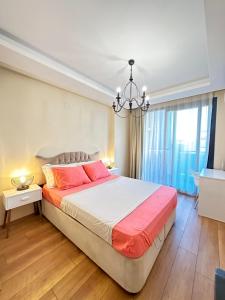 a bedroom with a large bed and a chandelier at Yeni denize yakın minimalist evler in Mersin