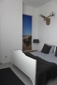 a bedroom with two beds and a view of the beach at Raadhuis Egmond in Egmond aan den Hoef