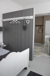 1 dormitorio con cama blanca y pared gris en Raadhuis Egmond, en Egmond aan den Hoef