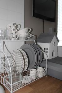 a white dish drying rack with dishes and a house at Raadhuis Egmond in Egmond aan den Hoef