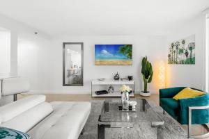 a living room with a white couch and a table at Bnb Hyperion - Ocean View - 3BR Condo w Pool & GYM in Miami