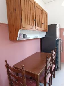 a kitchen with a wooden table and a refrigerator at GOLDEN BEACH in Souvala