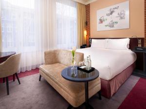 a hotel room with a bed and a chair at Sofitel Legend The Grand Amsterdam in Amsterdam