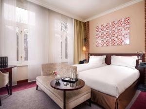 a hotel room with a bed and a couch at Sofitel Legend The Grand Amsterdam in Amsterdam