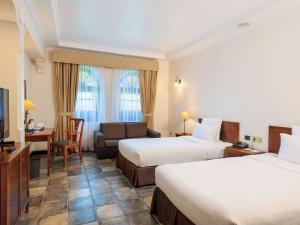 een hotelkamer met 2 bedden en een bank bij Novotel Bahrain Al Dana Resort in Manamah