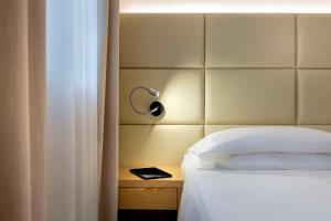 卡達諾阿坎波的住宿－貝斯特韋斯特卡瓦利瑞德拉科洛納酒店，一间卧室配有一张带床头板和灯的床