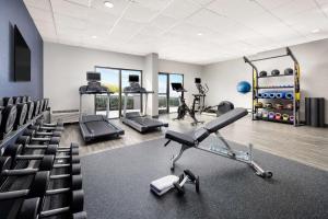 Hampton Inn Laredo في لاريدو: صالة ألعاب رياضية مع آلة ركض وكراسي في غرفة
