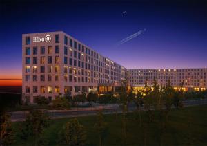 ein Gebäude mit einem Baumschild darauf in der Nacht in der Unterkunft Hilton Beijing Capital Airport in Shunyi