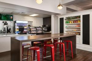 a kitchen with a bar with red stools at Redmont Hotel Birmingham - Curio Collection by Hilton in Birmingham