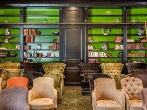 a library with green walls and chairs and books at La Cour des Consuls Hotel and Spa Toulouse - MGallery in Toulouse