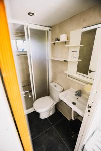 a small bathroom with a toilet and a sink at Loredo Surf House in Loredo