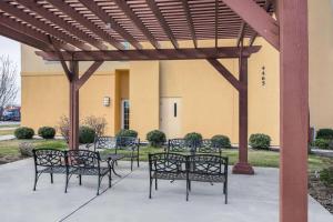 a group of benches sitting under a pergola at La Quinta by Wyndham Denton - University Drive in Denton