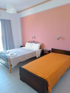 two beds in a room with pink and orange at GOLDEN BEACH in Souvala