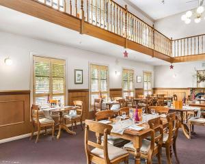 a restaurant with tables and chairs and a staircase at Quality Inn Colonial in Bendigo