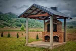 un horno de ladrillo con techo en un campo en Etno Kutak Purtić, en Ljubovija