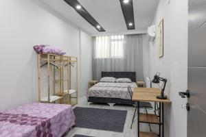 a bedroom with two beds and a table and a desk at 4-3 Yatak Odalı Büyük Daire Kaleiçi Yakını in Antalya