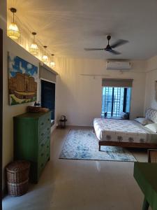 a bedroom with a bed and a green dresser at Nagarik Commune, Baner - Pune in Pune