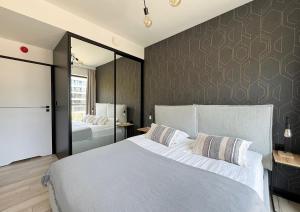 a bedroom with a large white bed and a wall at Shellter Prestige Przy Wydmie in Rogowo