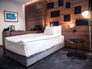 a bedroom with a large bed with a wooden wall at Best Western Premier Natalija Residence in Belgrade