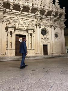 Ein Mann steht vor einem großen Gebäude. in der Unterkunft Dolce Vita Rooms in Lecce