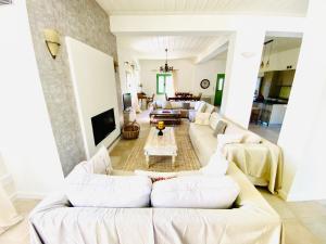 a living room with white couches and a tv at Seaview and Olives Panorama Villa Joyanna in Mani in Kalívia