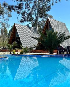 a house with a swimming pool in front of it at Eucalyptus Cottages in Chakvi