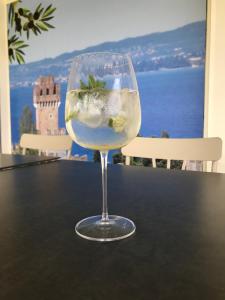 een glas wijn bovenop een tafel bij Camere Girasole in Lazise